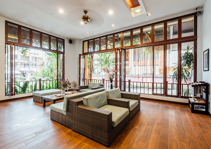 Living room with wicker sofas and large wooden-framed windows