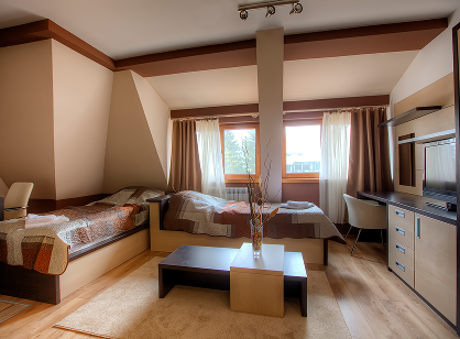 Cozy hotel room with slanted ceilings, two beds, and a desk