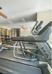 Modern gym with a row of treadmills and other fitness equipment