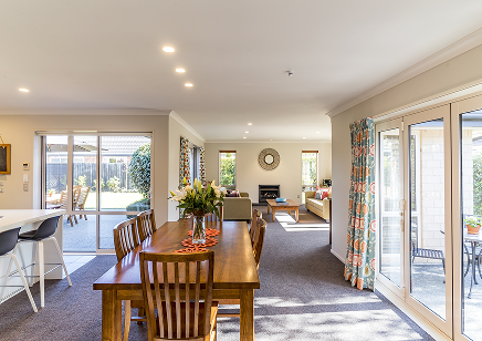 Bright and open plan living and dining area with a long wooden table